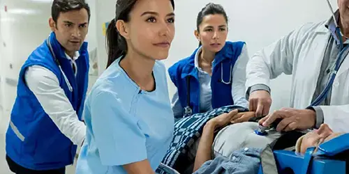 Medical staff wheeling a patient through a hospital hallway