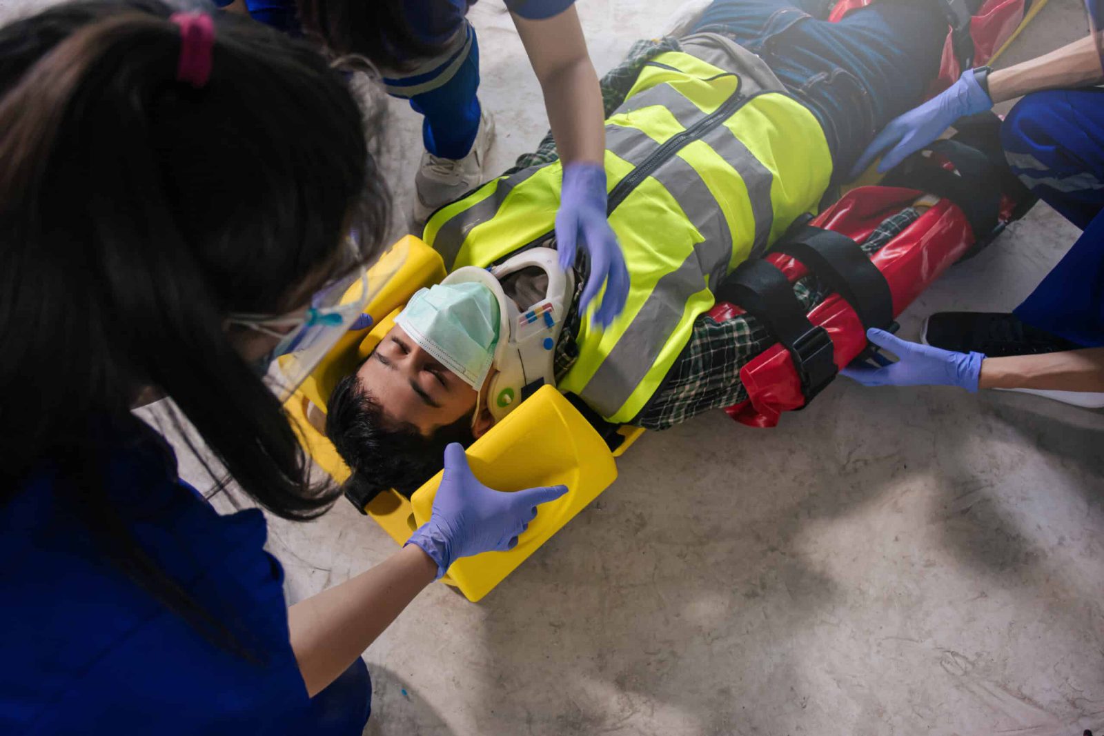 Team EMS paramedic first aid for head injuries. Paramedic team first aid builder accident in site work.