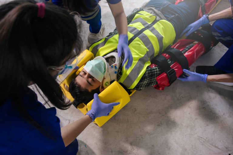 Team EMS paramedic first aid for head injuries. Paramedic team first aid builder accident in site work.