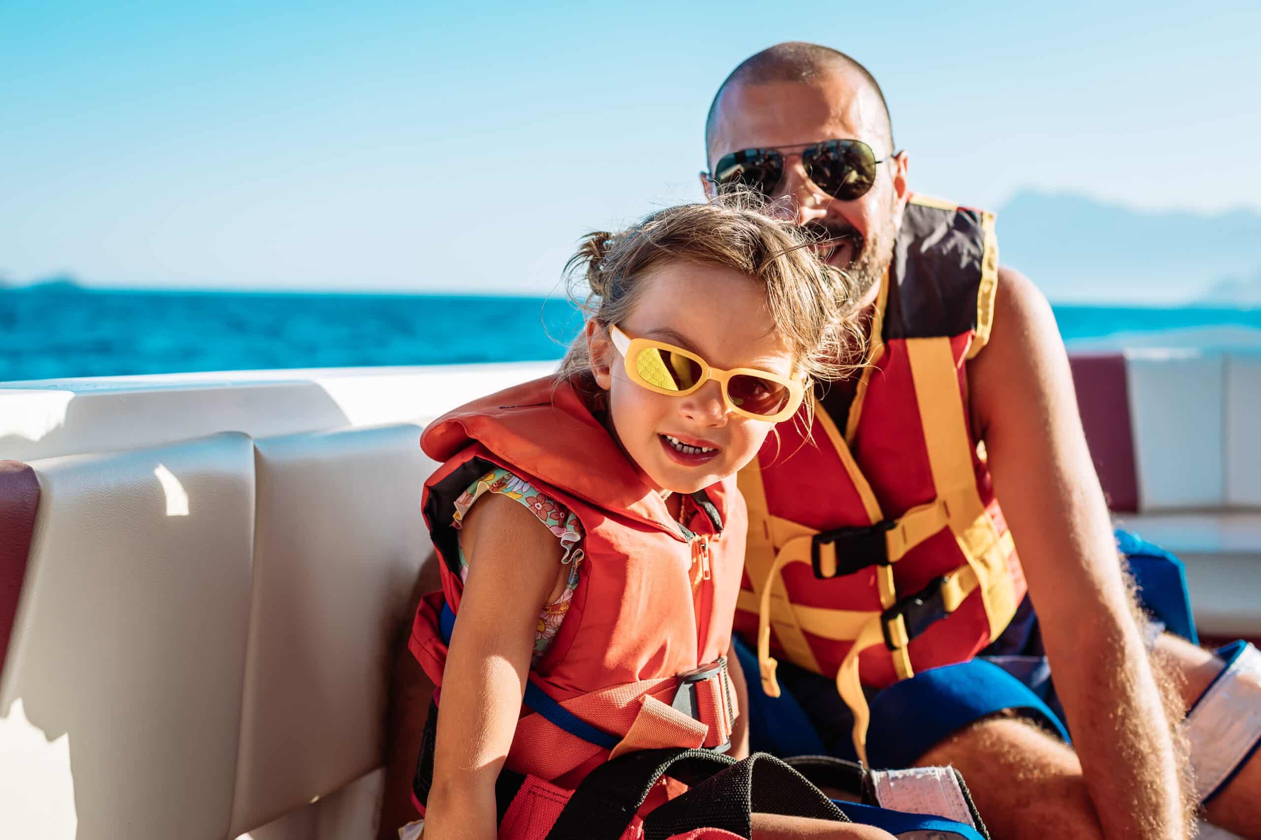 father and daughter wearing life jackets on a boat
