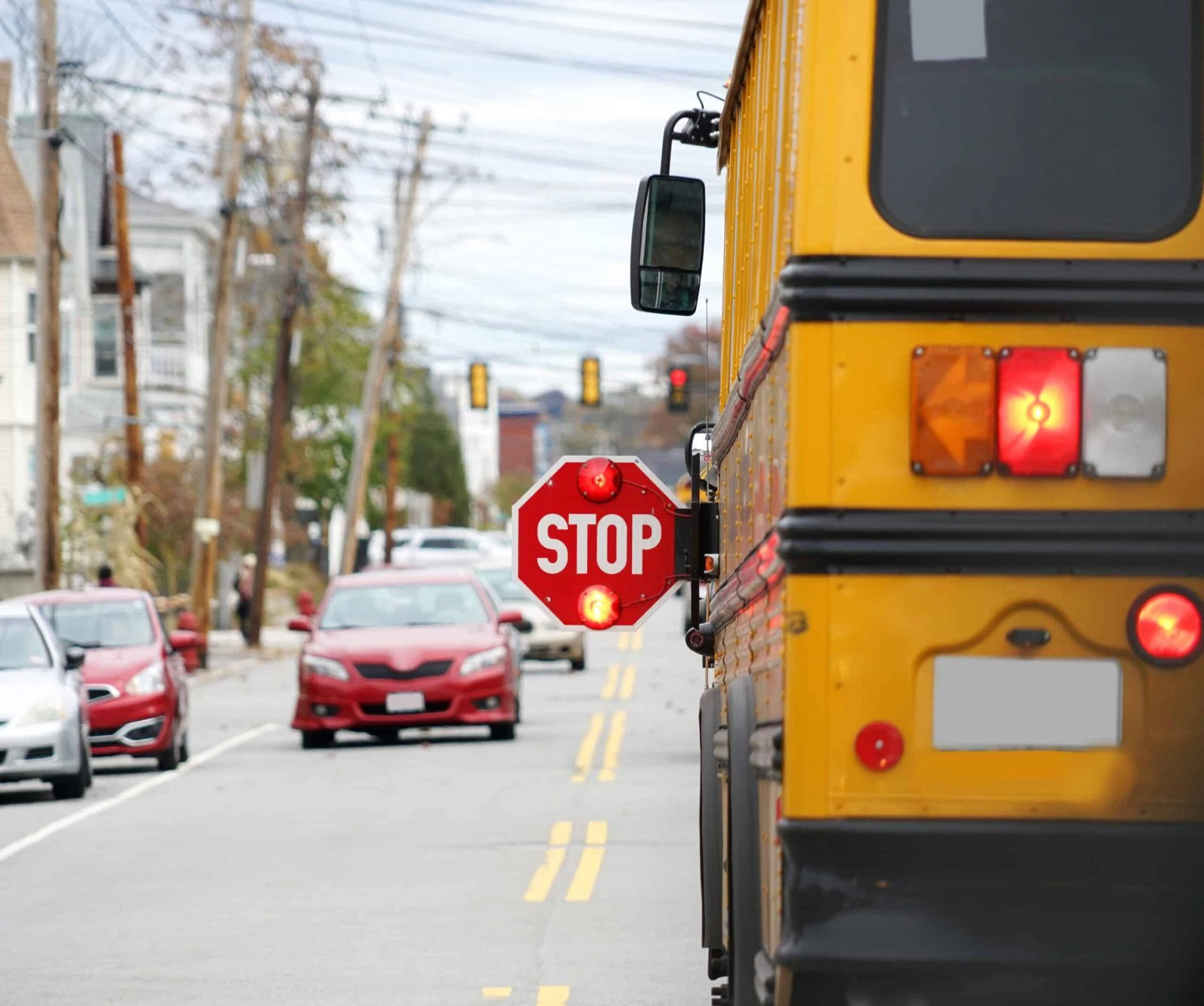School Bus Stop Sign Yellow school bus with stop sign extended on a city street during daytime.